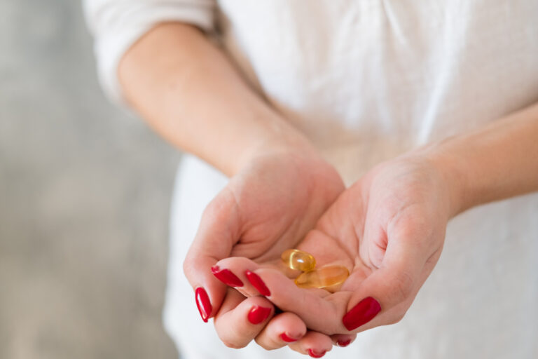 woman holding vitamins that might have a vitamin deficiency