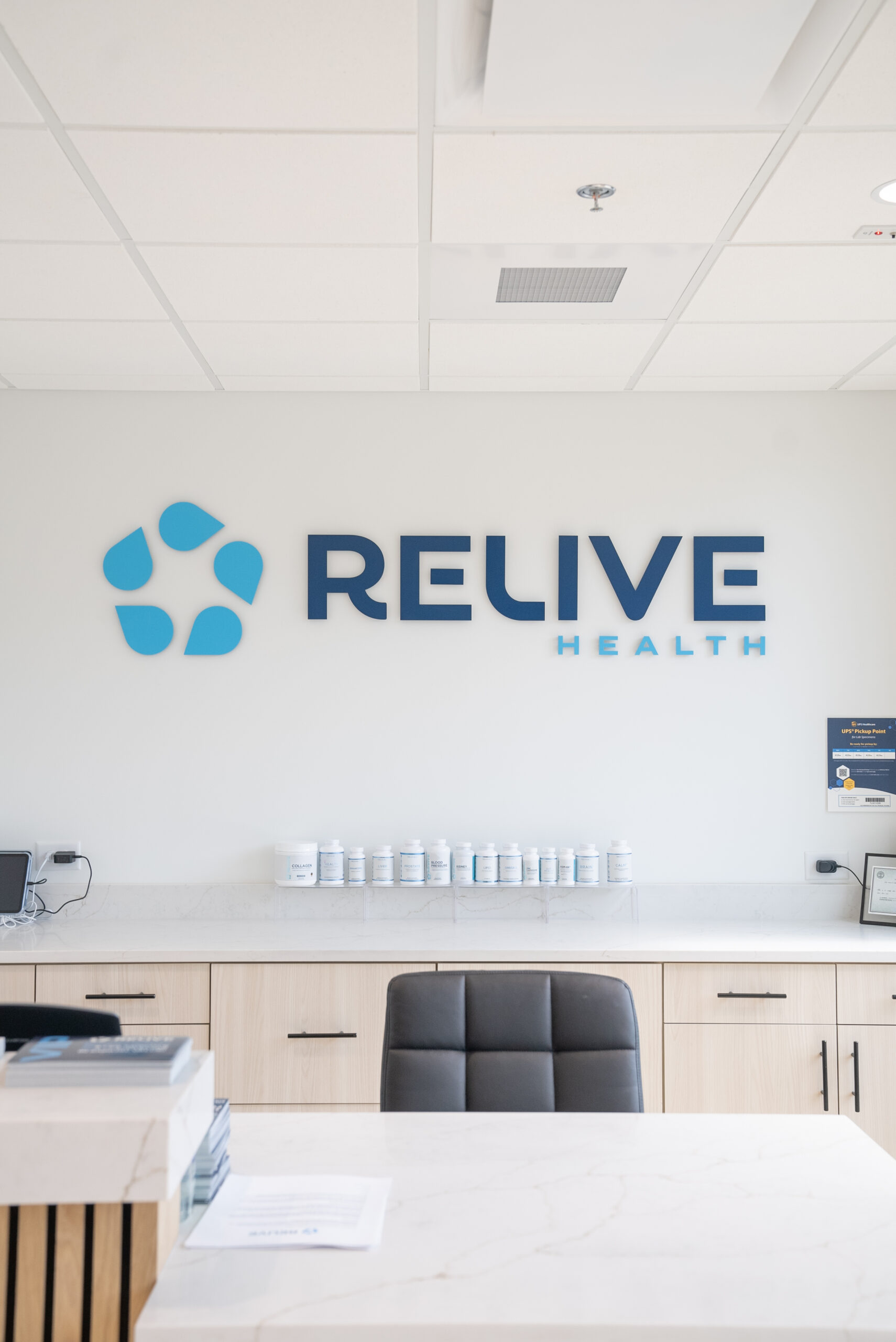 The front desk and lobby reception area featuring the Relive Health logo sign at our stem cell injection clinic in Brentwood.