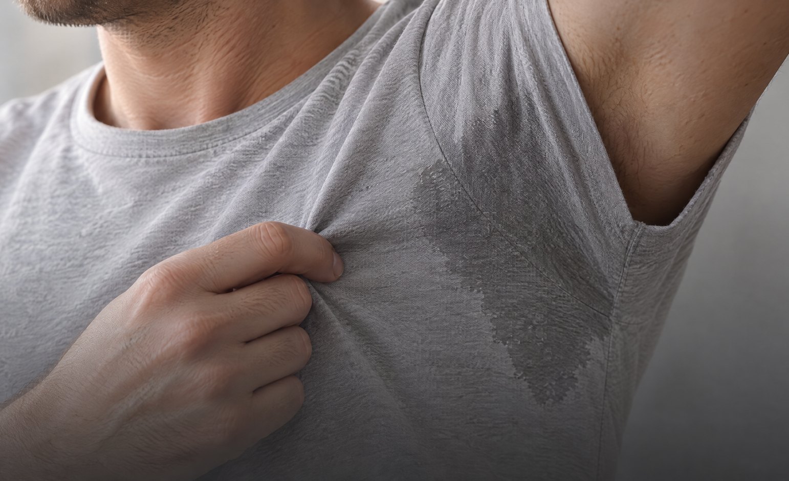 Underarm sweat patch on a grey t-shirt